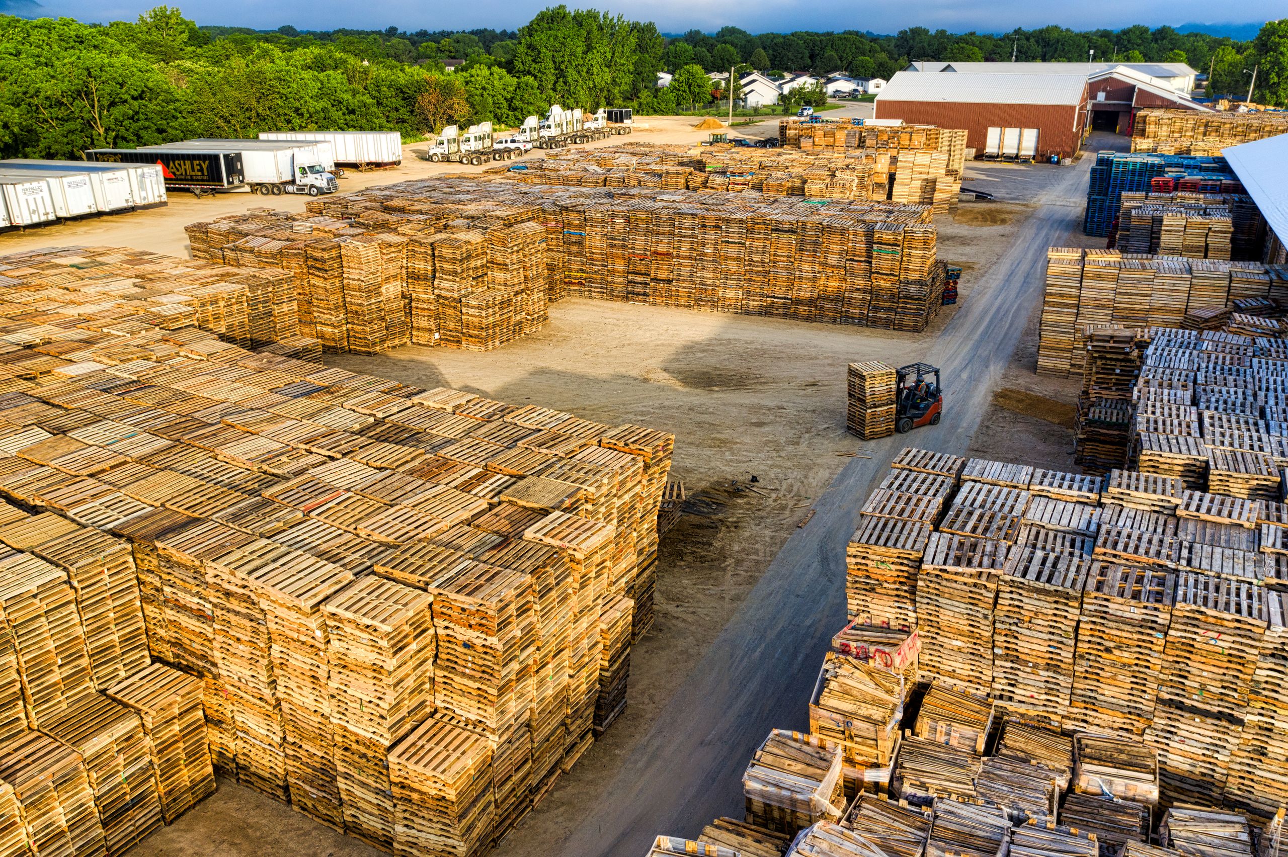 Aerial view showcasing large stacks of wooden pallets in an outdoor storage facility in Lake City, MN.
